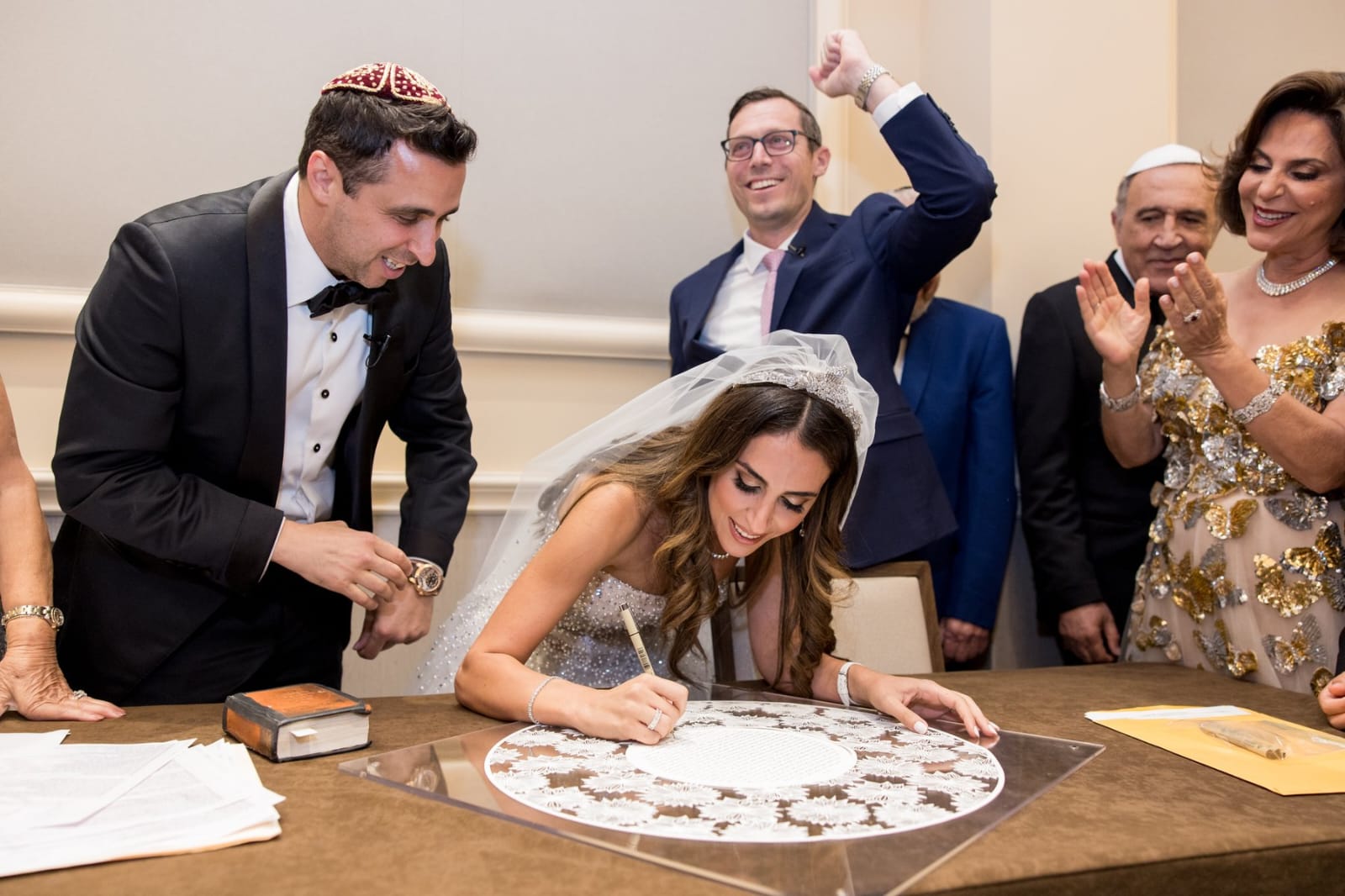 Signing the ketubah, surrounded by family.
